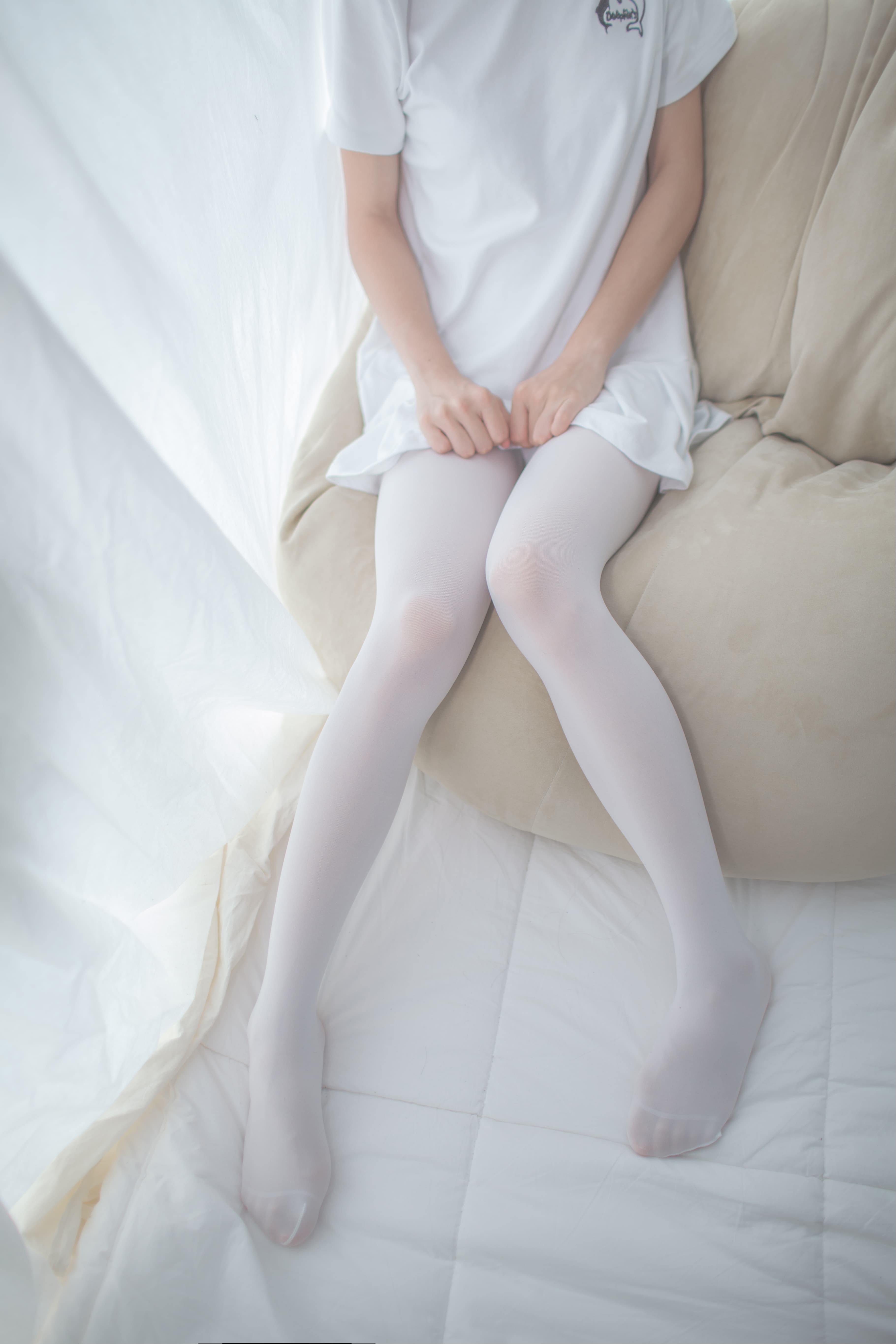 Close-up of white pantyhose hugging arch with subtle wrinkles and glossy toe silhouette